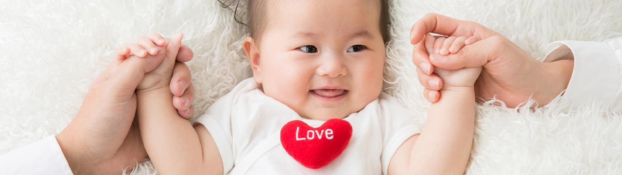 両手を握られている赤ちゃん